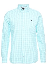 Ljust blå rutigt långärmad skjorta med knapp-ner krage och vita knappar. Har en liten logotyp på bröstet.