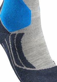 Calzini grigi e blu navy con accenti blu. Presentano una texture a coste e un design grafico sulla caviglia. Il materiale sembra morbido ed elastico.