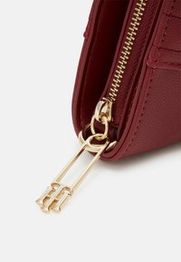 Burgunderfarbene Kunstledertasche mit goldenen Reißverschluss und Beschlägen. Verfügt über eine strukturierte Oberfläche und eine rechteckige Form mit einem eleganten Design.