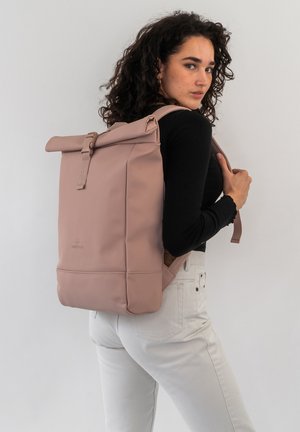 Rosa Rolltop-Rucksack aus glattem, wasserdichtem Material mit verstellbaren Trägern und einem Druckknopfverschluss. Verfügt über ein dezentes Logo, das auf der Vorderseite eingeprägt ist.
