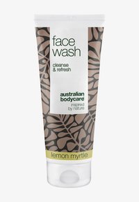 Tub med ansiktstvätt med brunt mönster och vit etikett. Texten inkluderar "cleanse & refresh" och "lemon myrtle" i grönt och gult.