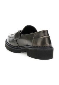 Černé kožené loafery s tlustou gumovou podrážkou, prošíváním a přeloženým popruhem přes vrch, zobrazené ze zadní strany.