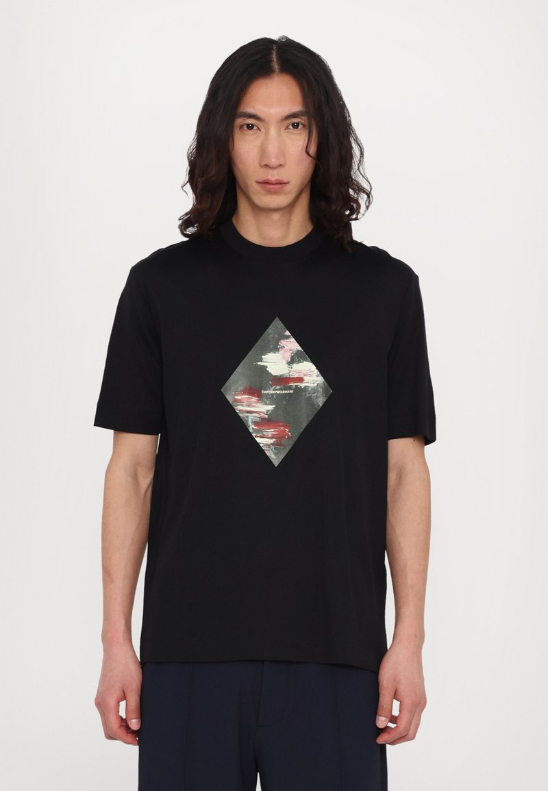 Tricou din bumbac negru, cu un grafic în formă de diamant în culori estompate, cu modele abstracte. Mâneci scurte și design cu gât rotund.