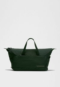 Ciemnozielona torba sportowa o gładkiej teksturze, z solidnymi rączkami i podwójnymi zamkami błyskawicznymi. Posiada subtelne logo w dopasowanym odcieniu.