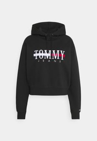 Sudadera corta negra hecha de tejido suave con un logotipo bordado "TOMMY JEANS" en blanco, rojo y azul en la parte delantera. Incluye un capucha con cordón.