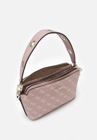 Rosa Guess-Handtasche mit Monogrammmuster, goldenem Logo, Reißverschluss und breitem Tragegurt mit runden Metallösen.