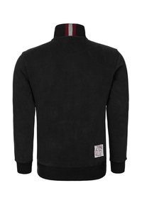 Černá bunda na zip z měkké látky, s vysokým límcem s červenými a šedými pruhy a žebrovaným lemem a manžetami. Na boku je štítek.