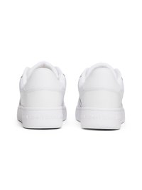 Hvide sneakers med en glat syntetisk overdel, rund tå, polstret krave og logo på sålen. Flade snørebånd og subtile designelementer.