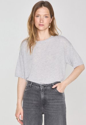 T-shirt grigio chiaro a maniche corte con una vestibilità rilassata, realizzato in tessuto morbido. Abbinato a jeans in denim grigio scuro a vita alta.
