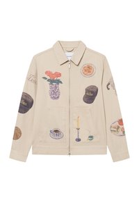 Μπεζ καμβάς μπουφάν με διάφορες καλλιτεχνικές εκτυπώσεις που περιλαμβάνουν λουλούδια, φαγητό και οικιακά αντικείμενα. Φερμουάρ εμπρός και δύο μπροστινές τσέπες.