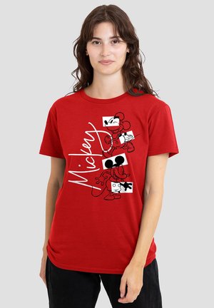 Woman wearing a red t-shirt with two black line-art Mickey Mouse characters and "Mickey" written vertically in white script.