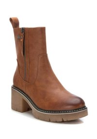 Stivaletto in finta pelle marrone con cerniera laterale, tacco spesso e suola texturizzata. Presenta dettagli cuciti e un tassello sul retro.