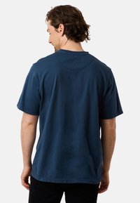 Laivansinisestä puuvillasta valmistettu t-paita, jossa on lyhyet hihat, pyöreä kaula-aukko ja rento istuvuus. Materiaali näyttää pehmeältä ja siinä on vähäisesti tekstuuria.