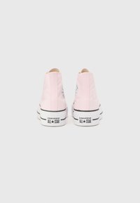 Rosa canvas högstövel sneakers med vita gummisulor och svarta detaljer, med en rund logotyp patch på den yttre hälen.