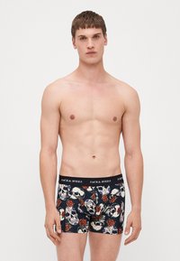 Schwarze Boxershorts mit einem wiederholten Skull- und Rosenmuster, elastischer Bund mit "JACK & JONES" Branding, aus dehnbarem Stoff.