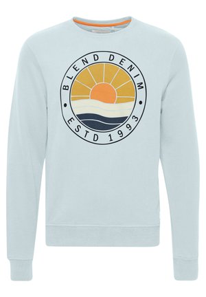 Hele sinine dressipluus, millel on ringikujuline graafika, kus on kujutatud päike ja lained, millel on kirjad "BLEND DENIM" ja "ESTD 1993". Ribitud varrukad ja alläär.