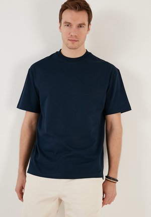 Tricou cu mânecă scurtă, de culoare bleumarin, fabricat din bumbac, cu guler rotund, fit lejer și textură netedă. Fără modele sau accente vizibile.
