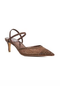 Brown pointed-toe slingback heels with crisscross straps, embellished with small beads, and a textured fabric upper. 3-inch tapered heel.