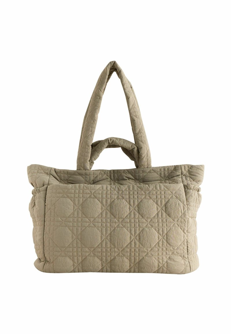 Sac fourre-tout matelassé de couleur beige clair, avec un motif texturé présentant des formes arrondies et deux poignées robustes pour un transport facile.