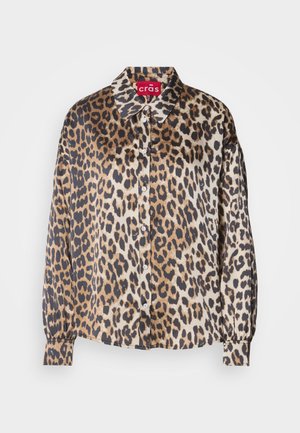 Blusa in stampa leopardata in tessuto setoso, con colletto classico, chiusura frontale con bottoni e maniche lunghe con polsini elastici. I colori includono beige e marrone.