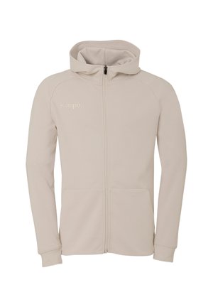 Veste à capuche beige clair avec fermeture éclair frontale, deux poches, manches longues et logo "Kempa" sur la poitrine gauche.