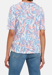 Kortärmad, avslappnad topp i lätt tyg. Har en vit bas med blå och rosa blad- och prickmönster.