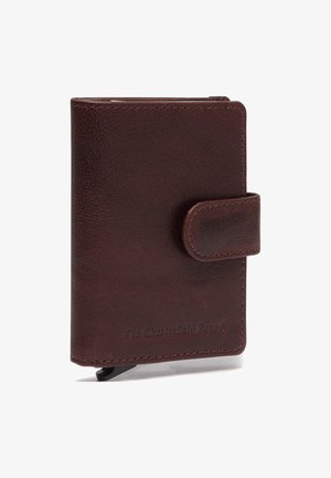 Braune Lederbörse mit strukturierter Oberfläche, Druckverschluss und sichtbaren Nähten. Mit eingeprägtem Markennamen auf der Vorderseite.