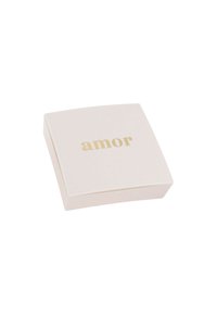 Caja cuadrada blanca con bordes redondeados, que presenta la palabra "amor" en letras doradas en la superficie superior. Textura suave, diseño minimalista.