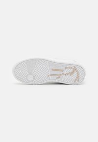 Semelle de sneaker blanche avec un motif de semelle géométrique et un logo en relief de couleur beige clair. Texture lisse avec des bords arrondis.