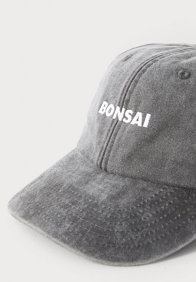 Halljuhlinne halli puuvillane müts koos kumerate äärega, millel on ees valge brodeeritud tekst "BONSAI". Pehme tekstuur ja nähtavad õmblusdetailid.