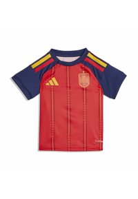 Sarkans un tumši zils īsām piedurknēm futbola kreklis ar dzeltenām svītrām uz pleciem, Spānijas nacionālās komandas emblēma un Adidas logo priekšpusē.