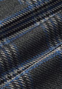 Tkanka o teksturowanym splocie z czarnym, szarym i niebieskim wzorem w kratę. Materiał jest miękki, układa się dobrze i jest lekko połyskujący.