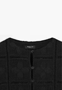 Czarny dzianinowy kardigan na szydełku z okrągłym dekoltem i trzema guzikami z przodu, ozdobiony misternymi spiralnymi i kwiatowymi wzorami.