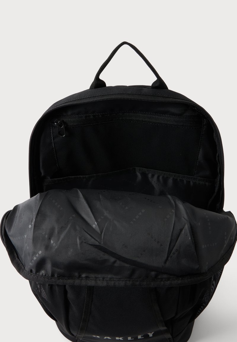 Schwarzer Rucksack mit oben offenem Reißverschluss, der die innere Reißverschlusstasche und das gepolsterte vordere Fach zeigt, schwarzer Stoffgriff oben.