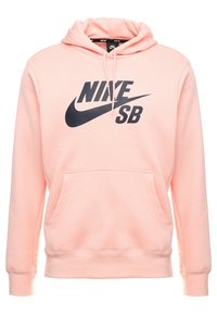Ljusrosa Nike SB-hoodie med svart logotyp, framfickor som en känguru, dragsko på huvan och långa ärmar.