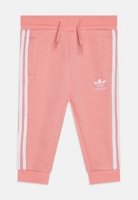 Pantaloni de trening roz deschis cu dungi laterale albe, talie elastică și două buzunare frontale. Prezintă un logo mic alb pe coapsa stângă.
