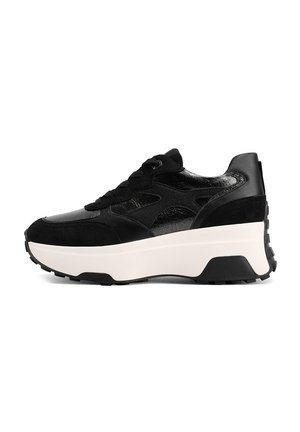 Sneaker nera con un mix di suede opaco e materiale lucido. Suola intermedia bianca spessa, suola nera texture e design classico con lacci.