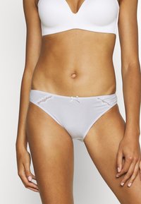 Mutande donna grigio chiaro in un materiale liscio, con dettagli in pizzo ai lati e un piccolo fiocco di satin al centro davanti.