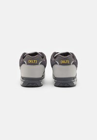 Gray and black athletic shoes with a textured suede upper, rubber sole, and yellow [XLT] branding on the heel. Rounded design, cushioned collar.