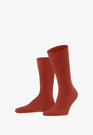 Red cotton socks with ribbed cuffs and smooth texture. Features a reinforced toe and heel with a small brand logo near the toe.