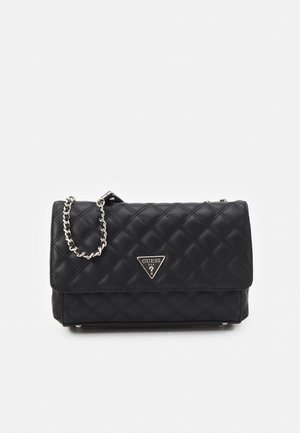 Sac à main noir matelassé avec une bandoulière en chaîne, présentant une plaque de logo triangulaire. Texture lisse et design structuré, forme compacte.