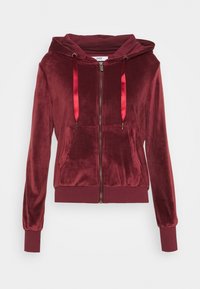 Sudadera de terciopelo burdeos con cremallera, que presenta un bolsillo frontal, cordones rojos y puños y dobladillo acanalados. Textura suave y diseño ajustado.