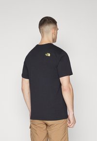 The North Face EASY TEE - Camiseta estampada - black/sun yellow