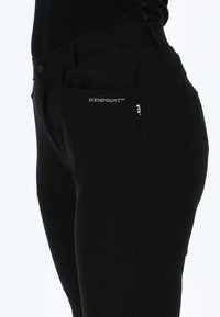 Zwarte stretchbroek met een gladde textuur, voorzien van voorzakken en het "SWEDEMOUNT™" logo in het wit op de tailleband en zijkant.