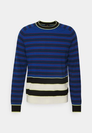 Blå rutigt tröja med röda och svarta detaljer, med en svart och gul ribbad halsringning. Mjuk textur och avslappnad passform.