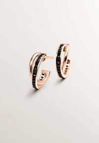 Pendientes de aro en oro rosa con un diseño ondulado, que presentan una banda de piedra negra en el centro, acabado brillante y cierre de presión.