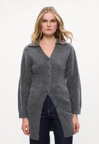 Γκρι πλεκτή ζακέτα με γιακά, κουμπιά μπροστά και ανοίγματα στο τελείωμα. Μαλακή υφή με ριμπ μανίκια και σώμα. Casual σχεδιασμός κατάλληλος για στρώσεις.