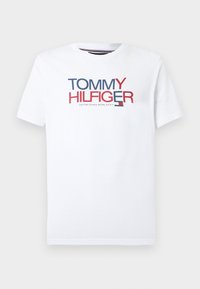 Λευκό βαμβακερό t-shirt με το λογότυπο "TOMMY HILFIGER" σε κόκκινο και μπλε. Κλασικός στρογγυλός λαιμός, κοντά μανίκια και ίσια σχεδίαση στο τελείωμα.