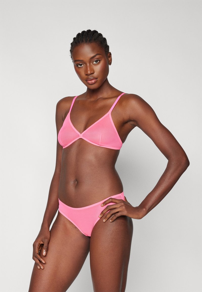 Completo bikini rosa composto da un reggiseno triangolare con spalline sottili e slip a vita bassa abbinati, realizzati in un tessuto morbido e elasticizzato.