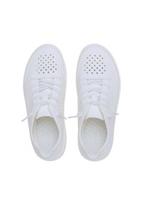 Le scarpe sportive bianche presentano una tomaia liscia e forata, un design con lacci e una suola imbottita con un interno testurizzato.
